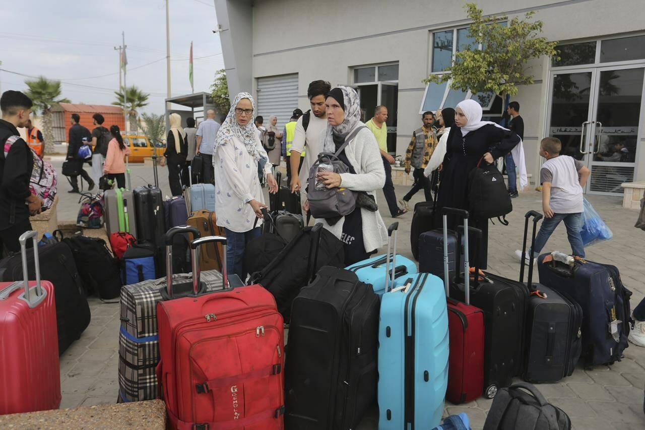 Palestinians arrive at the border crossing to Egypt in Rafah, Gaza Strip, on Monday, November 13, 2023. (AP Photo/Hatem Ali)