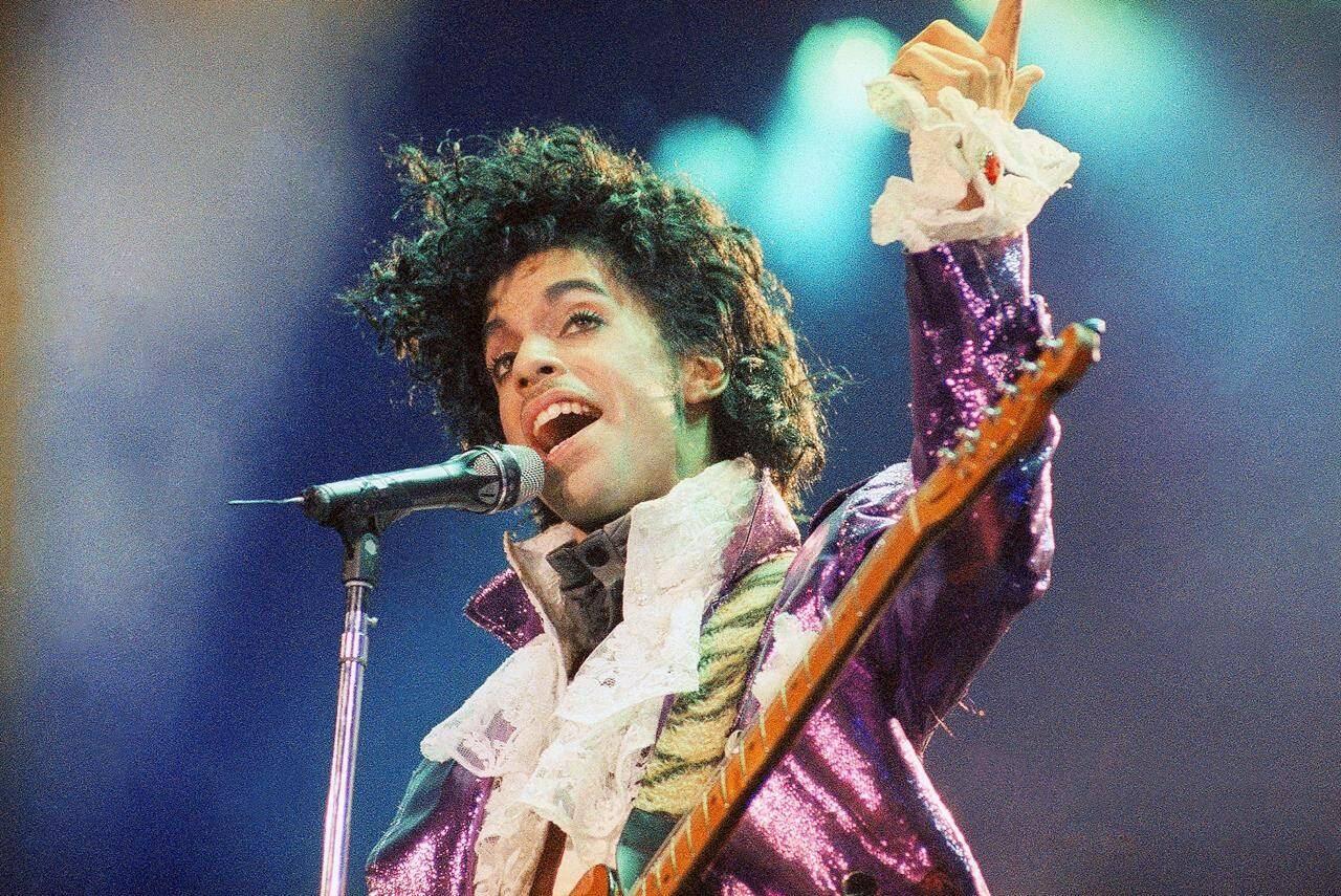 Prince performs at the Forum, Feb. 18, 1985, in Inglewood, Calif. Fans of Prince, who was known nearly as much for his extravagant wardrobe as for his chart-topping hits, will have a chance to bid on some of the late musician’s sartorial splendor in an online auction running through Thursday, Nov. 16, 2023. (AP Photo/Liu Heung Shing, File)