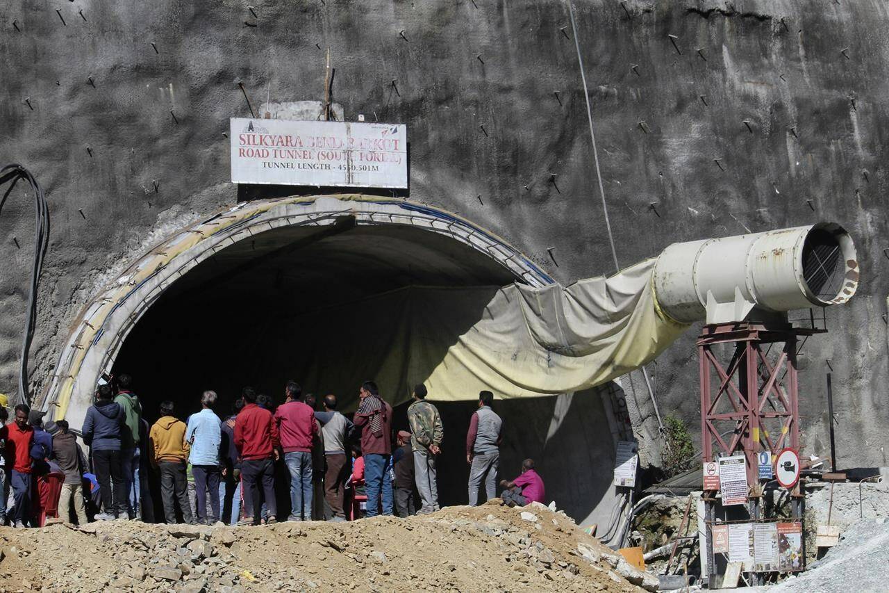 People watch rescue and relief operations at the site of an under-construction road tunnel that collapsed in mountainous Uttarakhand state, India, Wednesday, Nov. 15, 2023. Rescuers have been trying to drill wide pipes through excavated rubble to create a passage to free 40 construction workers trapped since Sunday. About 200 disaster relief personnel have been using drilling equipment and excavators in the rescue operation with the plan to push steel pipes 2.5-foot (0.76 meter) -wide through an opening of excavated debris with the help of hydraulic jacks to safely pull out the stranded workers. (AP Photo)