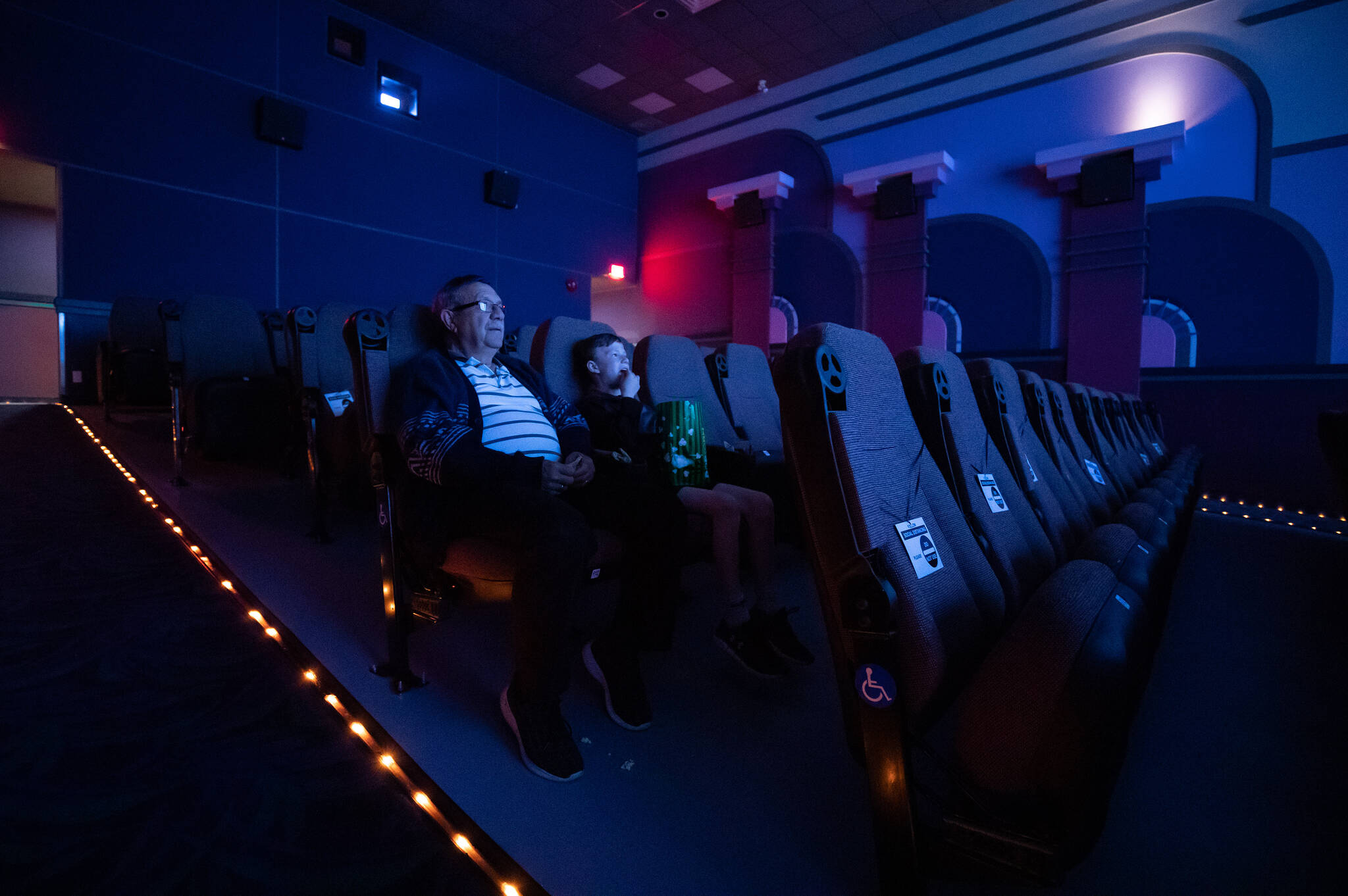 Andy Fillion, left, and his grandson Nicholas Fillion, 9, watch the movie Trolls World Tour at Caprice Cinemas, in Surrey, B.C., on Sunday, June 28, 2020. The B.C. film indutry may be past COVID and two Hollywood strikes, but a rebound has yet to arrive. THE CANADIAN PRESS/Darryl Dyck