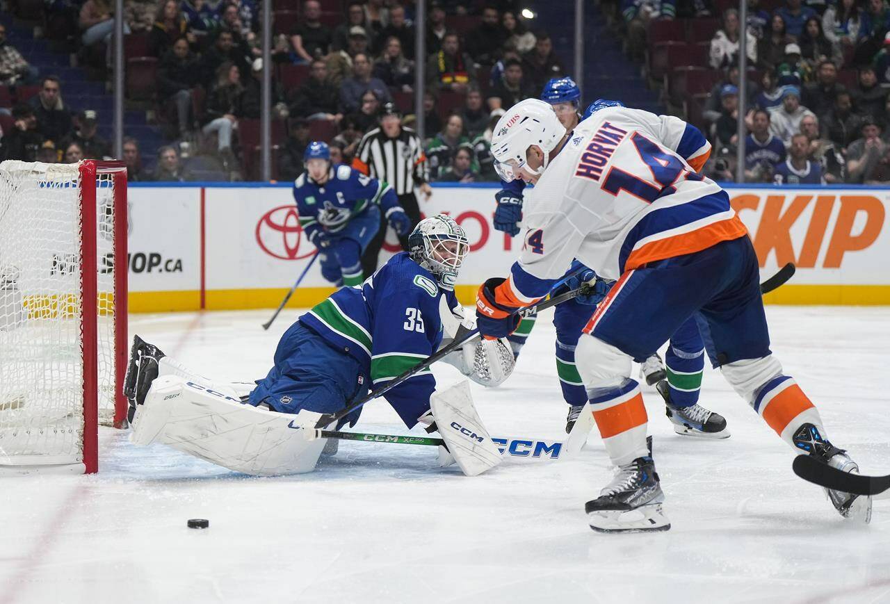 Vancouver Canucks goalie Thatcher Demko (35) watches as New York Islanders’ Bo Horvat (14) puts a shot wide of the goal during the second period of an NHL hockey game in Vancouver, on Wednesday, November 15, 2023. THE CANADIAN PRESS/Darryl Dyck