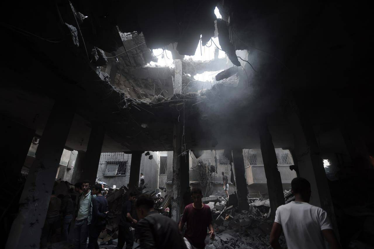 Palestinians look for survivors inside the remains of a destroyed building following an Israeli airstrike in Khan Younis refugee camp, southern Gaza Strip, Saturday, Nov. 18, 2023. THE CANADIAN PRESS/AP-Mohammed Dahman