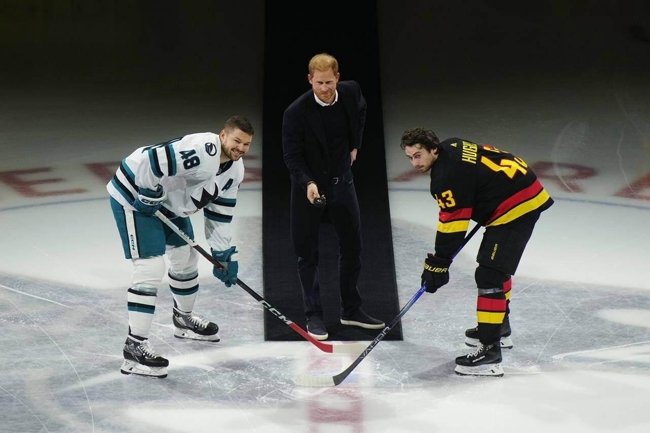 Prince Harry, Duke of Sussex, drops the puck for San Jose Sharks’ Tomas Hertl, left, and Vancouver Canucks’ Quinn Hughes during a ceremonial faceoff prior to an NHL hockey game in Vancouver, on Monday, November 20, 2023. The Invictus Games, founded by the Duke of Sussex, are scheduled to be held in Vancouver and Whistler in 2025. THE CANADIAN PRESS/Darryl Dyck