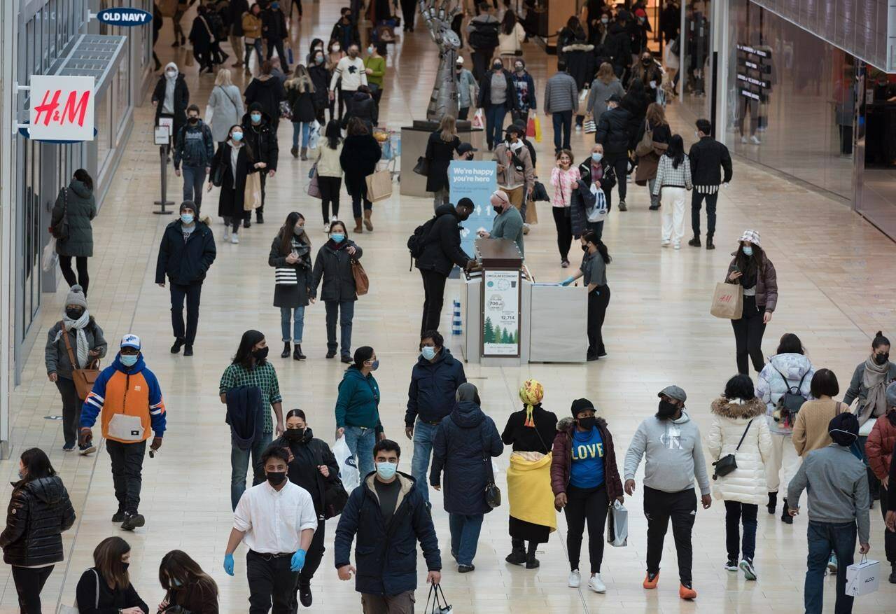 The barrage of Black Friday advertisements might have many tempted to whip out their wallets, but experts caution against unnecessary discretionary purchases this year amid inflation and the skyrocketing cost of living. People navigate through Yorkdale Mall in search of Black Friday sales in Toronto, Nov. 26, 2021. THE CANADIAN PRESS/Tijana Martin