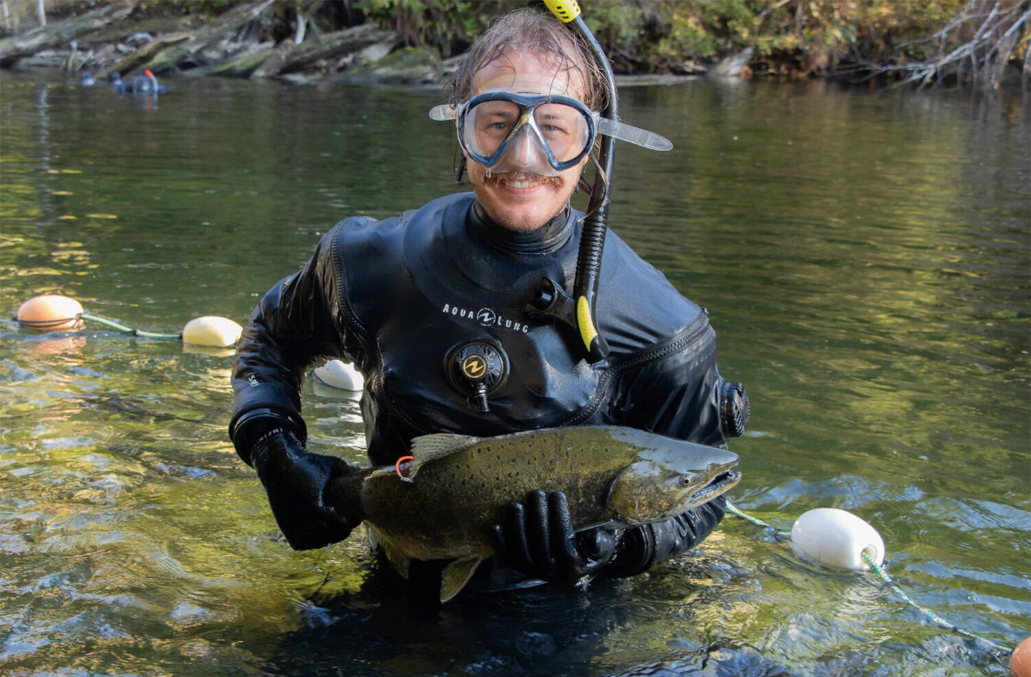 Zach Kapelan briefly holds a chinook salmon before releasing it back into HIŁSYAQƛIS/Tranquil Creek to spawn. Photo by Marc Fawcett-Atkinson/National Observer