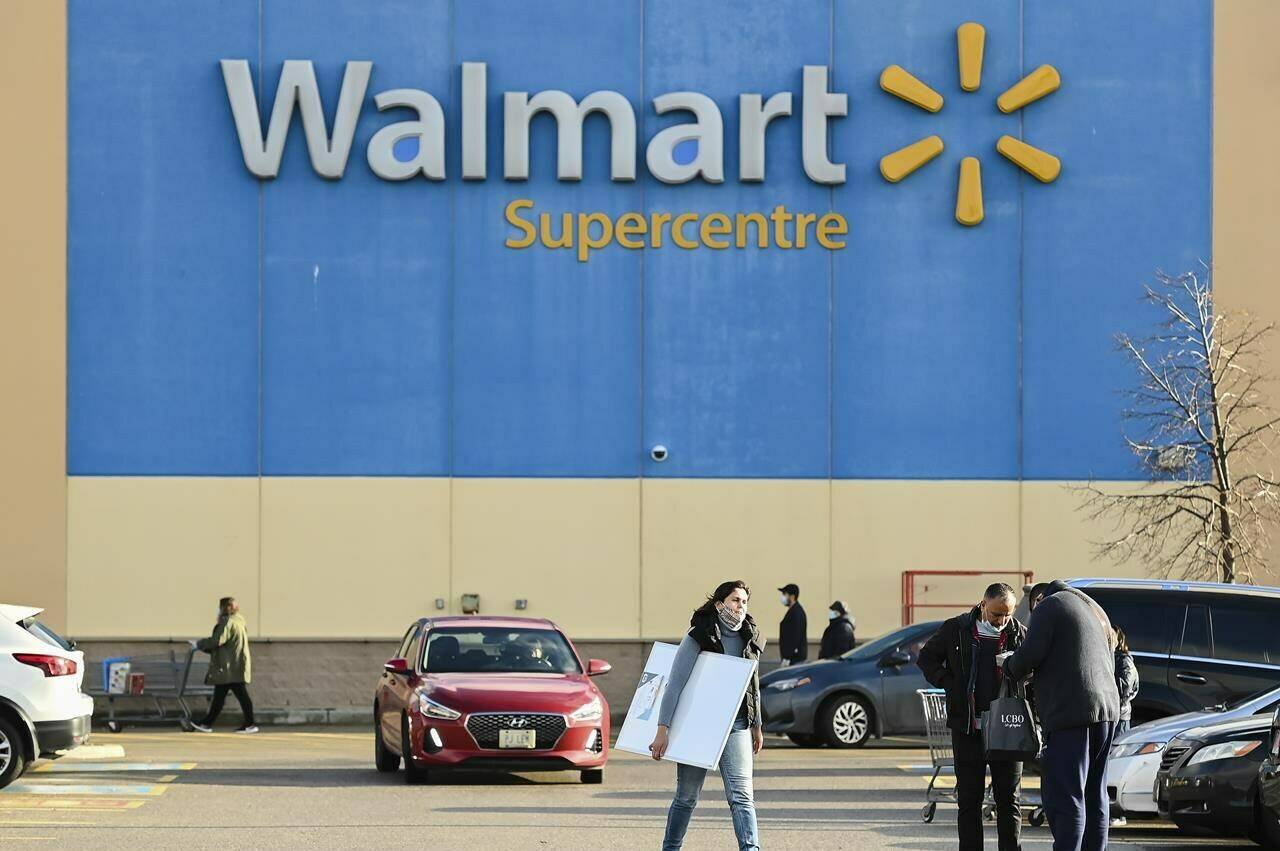 People leave the Walmart after shopping during the COVID-19 pandemic in Mississauga, Ont., Thursday, Nov. 26, 2020. Walmart Canada says it will invest nearly $1 billion this fiscal year on a slew of projects meant to modernize the retail giant’s Canadian footprint. THE CANADIAN PRESS/Nathan Denette