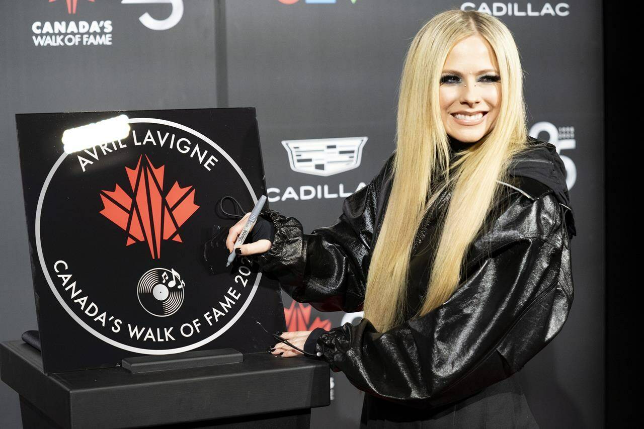 Musician Avril Lavigne signs her star at Canada’s Walk of Fame’s 25th Anniversary gala in Toronto, on Saturday, Dec. 2, 2023. THE CANADIAN PRESS/Arlyn McAdorey