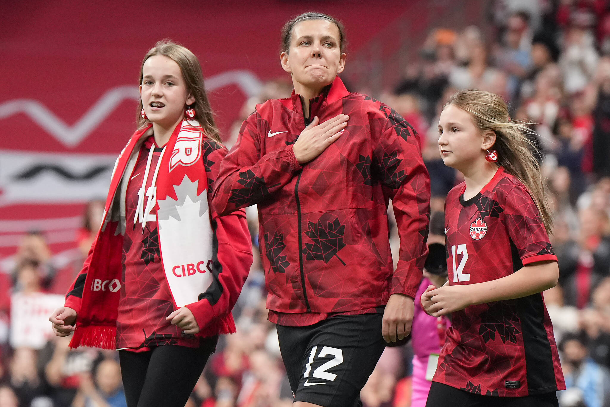 Canada’s national women’s soccer team captain Christine Sinclair reacts as she walks onto the field with her nieces Kaitlyn and Kenzie to be honoured before playing a friendly against Australia in her final international soccer match, in Vancouver, on Tuesday, December 5, 2023. Sinclair, 40, is making her 331st and final appearance for Canada. THE CANADIAN PRESS/Darryl Dyck
