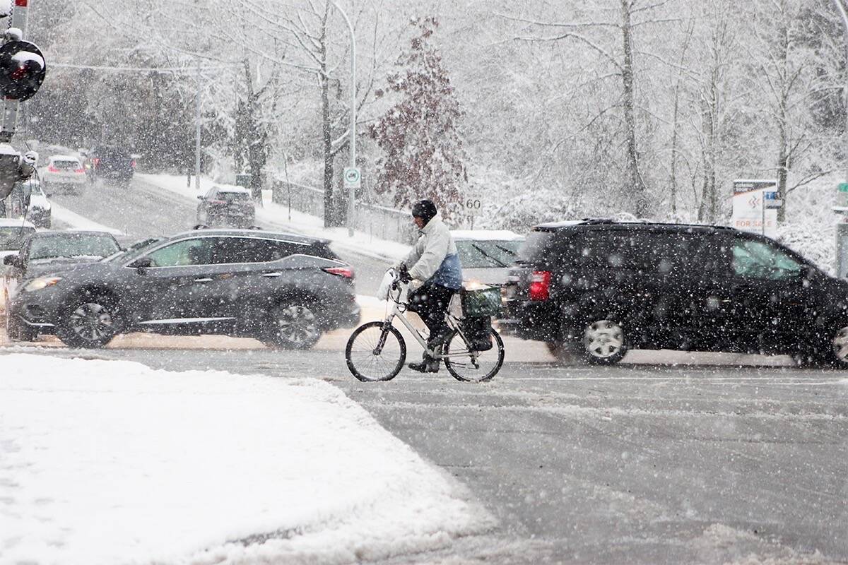 A man rides his bike in the snow at 152nd Street and 64th Avenue in Surrey in January of 2020. (Photo: Lauren Collins)