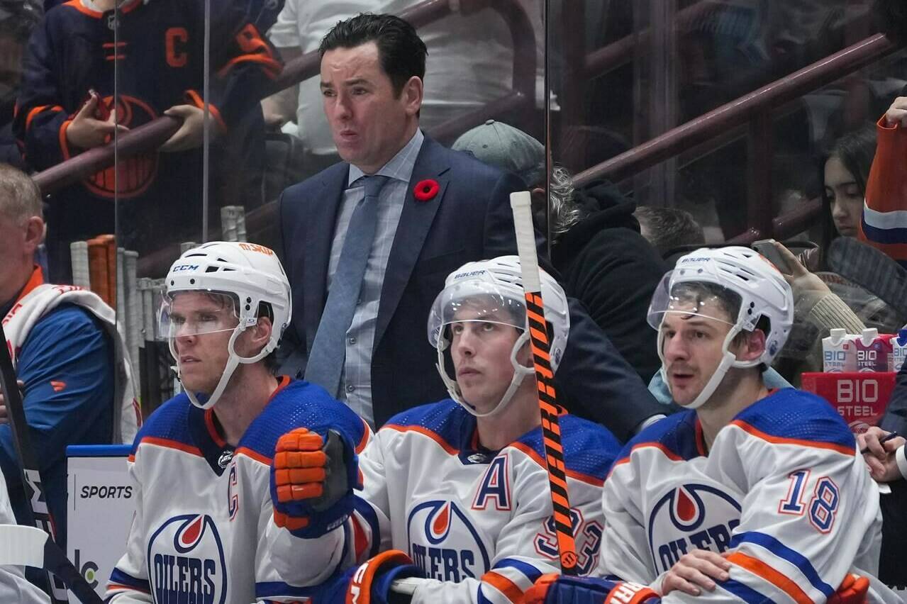 Edmonton Oilers head coach Jay Woodcroft, back, stands on the bench behind Connor McDavid, front from left to right, Ryan Nugent-Hopkins and Zach Hyman during the third period of an NHL hockey game against the Vancouver Canucks, in Vancouver, on November 6, 2023. Connor McDavid has played for five coaches in his nine NHL seasons. He's watched four walk out the door. "It's very hard," the Edmonton Oilers captain said of a bench boss getting fired. "Professional sports, people sometimes forget the human side of it. There's a relationship there. "These are people with families and it's hard." THE CANADIAN PRESS/Darryl Dyck