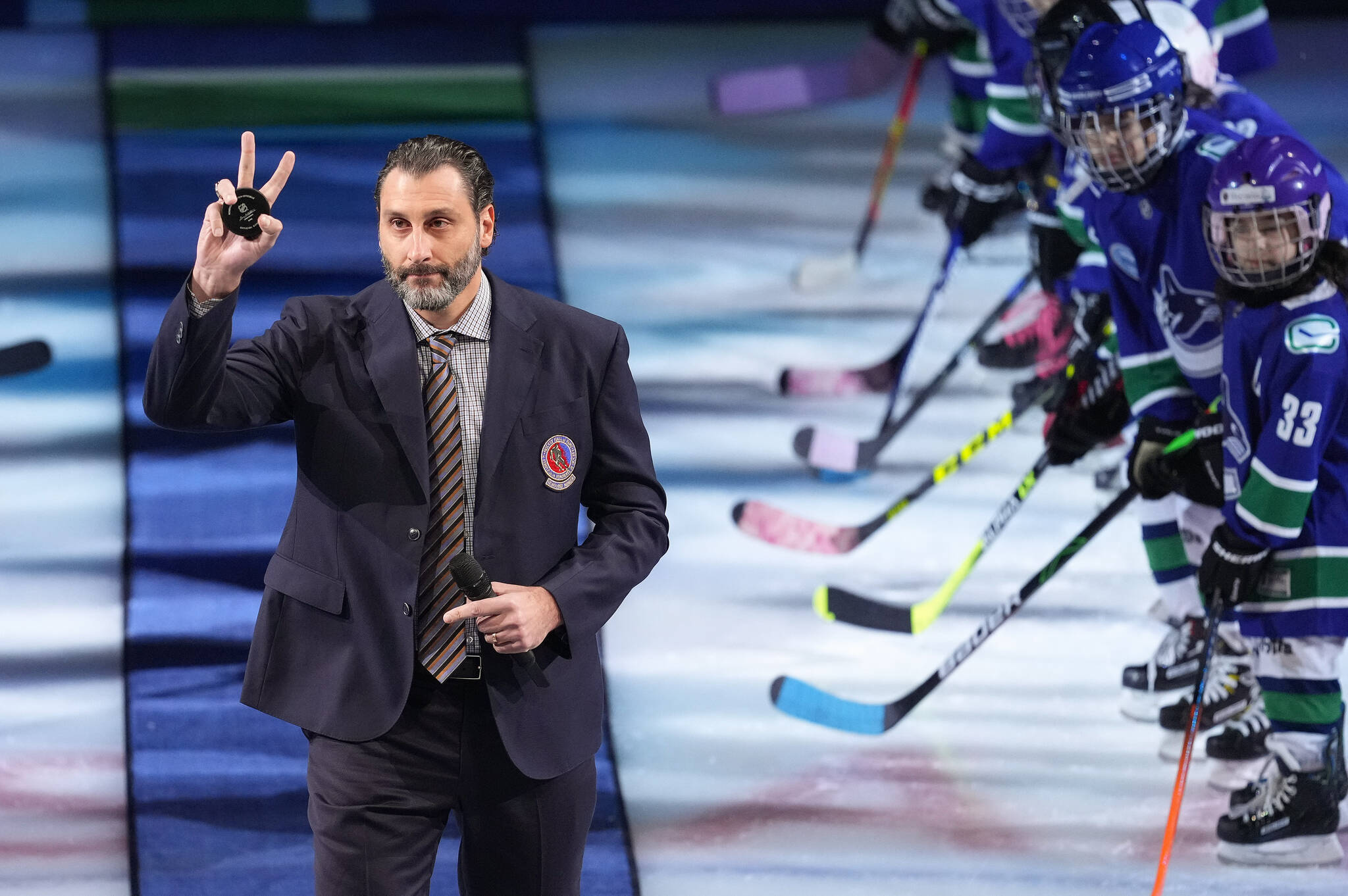 Former Vancouver Canucks goalie Roberto Luongo waves as he walks onto the ice to be honoured with other Hockey Hall of Fame inductees, Daniel and Henrik Sedin, before an NHL hockey game in Vancouver, on Thursday, December 1, 2022. THE CANADIAN PRESS/Darryl Dyck