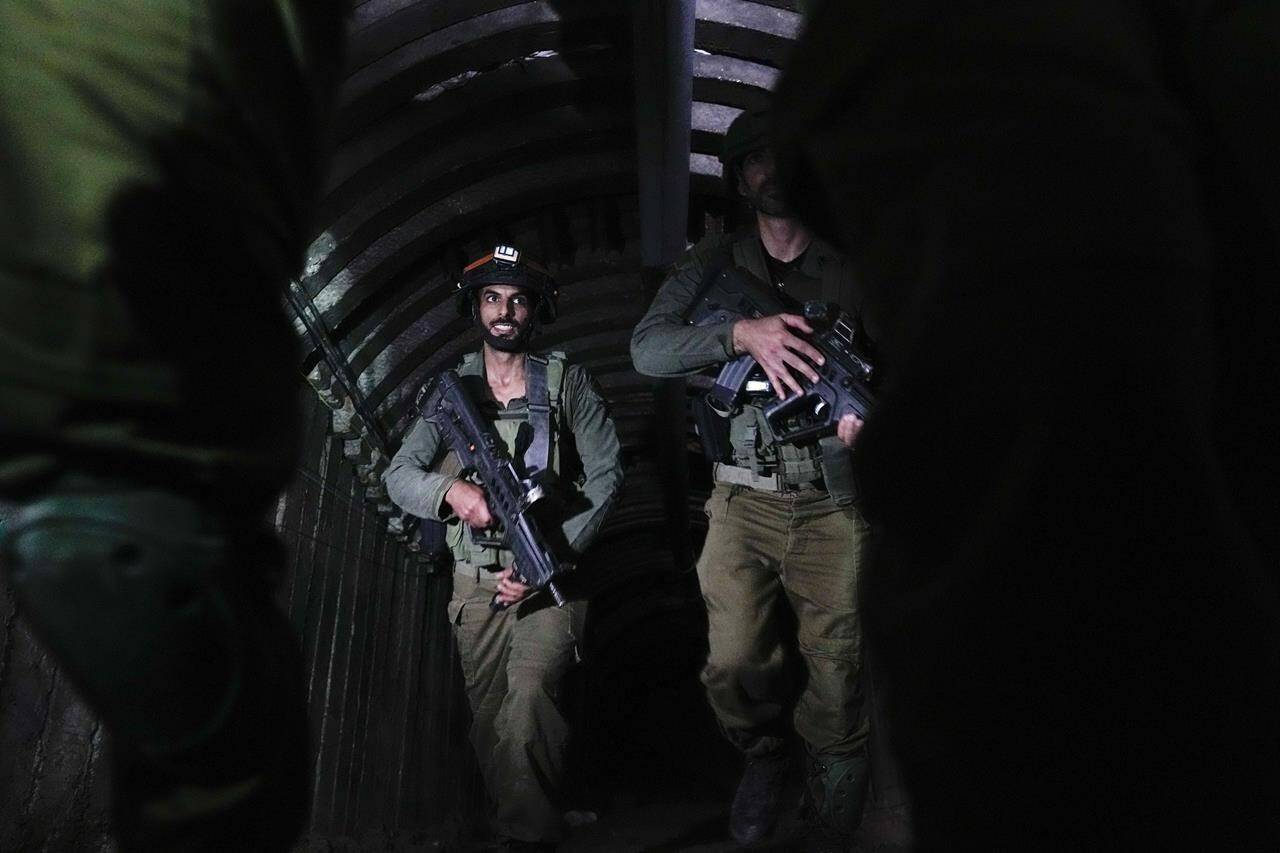 Israeli soldiers are seen in a tunnel that the military says Hamas militants used to attack the Erez crossing in the northern Gaza Strip, Friday, Dec. 15, 2023. The army is battling Palestinian militants across Gaza to retaliate for Hamas’ Oct. 7 attack on Israel. (AP Photo/Ariel Schalit)