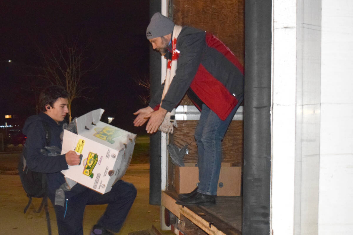 Salvation Army Major Michael Ramsay helps a student load a box of food into the Salvation Army truck at Alberni District Secondary School on Tuesday, Nov. 28. A new survey commissioned by the Salvation Army found almost seven out of 10 British Columbians faced food challenges last year. (ELENA RARDON / Alberni Valley News)