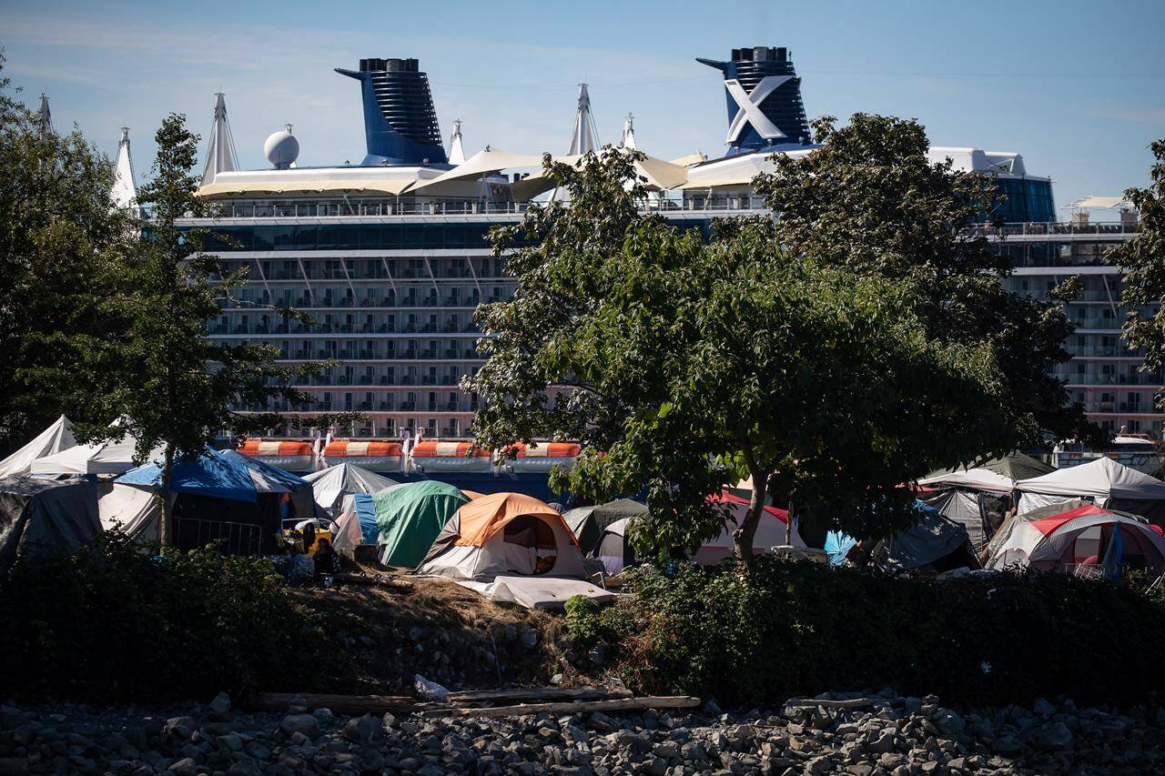 B.C. Human Rights Tribunal will hear a complaint from those who camp at Crab Park and allege the City of Vancouver and its park board discriminate against them by not providing “basic survival services.” Tents and people are seen at a homeless encampment at Crab Park as the Celebrity Cruises vessel Celebrity Eclipse is docked at port in Vancouver, B.C., Sunday, Aug. 14, 2022. THE CANADIAN PRESS/Darryl Dyck