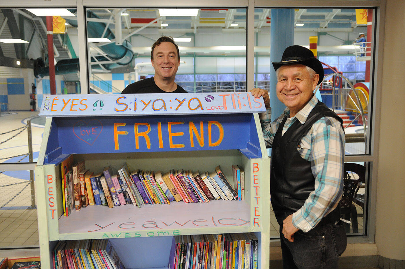 Shane Douglas (left), teacher at Seabird Island Community School, and Isadore Charters stand by the bookshelf that was modified and repainted by Douglas’s class. (Jenna Hauck/ Chilliwack Progress)