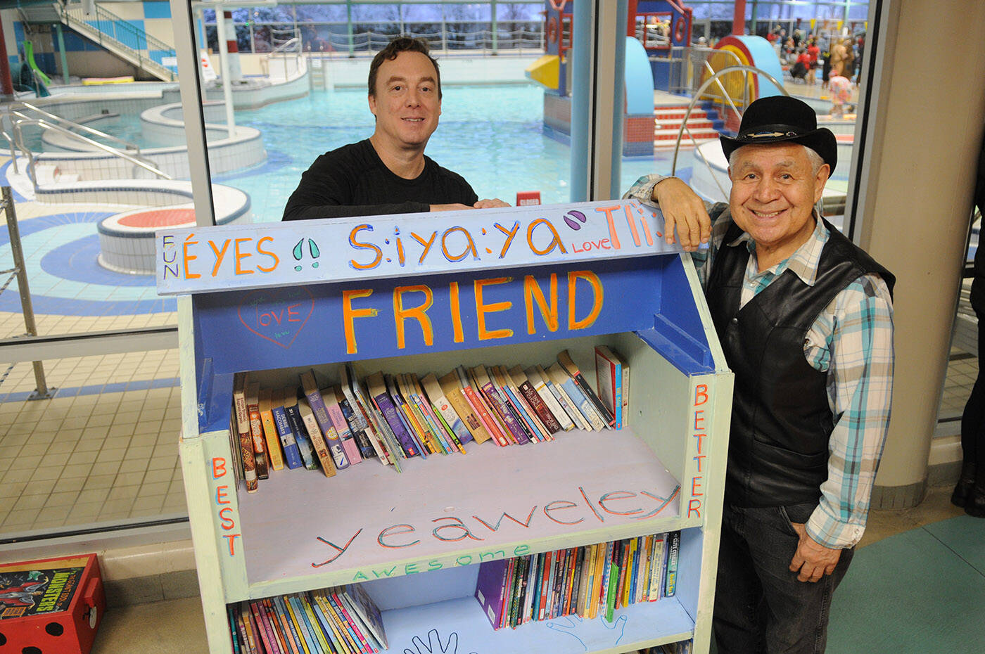 Shane Douglas (left), teacher at Seabird Island Community School, and Isadore Charters stand by the bookshelf that was modified and repainted by Douglas’s class. (Jenna Hauck/ Chilliwack Progress)