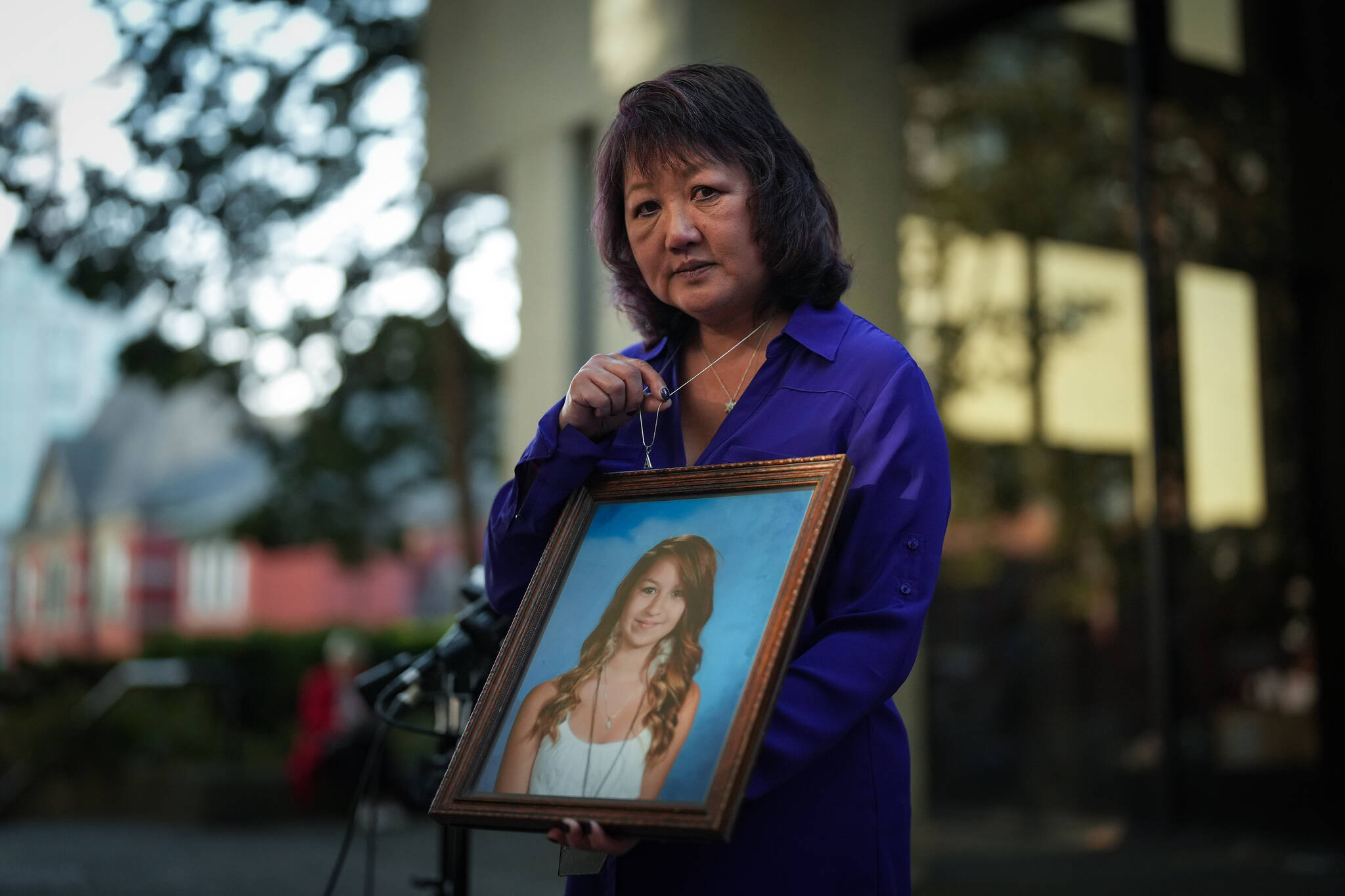 Carol Todd holds a photo of her late teenage daughter Amanda Todd, who died by suicide in 2012, and the necklace she was wearing in the school photo, outside B.C. Supreme Court after sentencing for the Dutch man who was accused of extorting and harassing her daughter, in New Westminster, B.C., on Friday, October 14, 2022. Todd said she had kept the necklace and “A” pendant stored away since her death and took it out for the first time in a decade to wear it to the sentencing. A British Columbia judge has sentenced Aydin Coban to 13 years in prison for tormenting Amanda Todd before she died by suicide. THE CANADIAN PRESS/Darryl Dyck