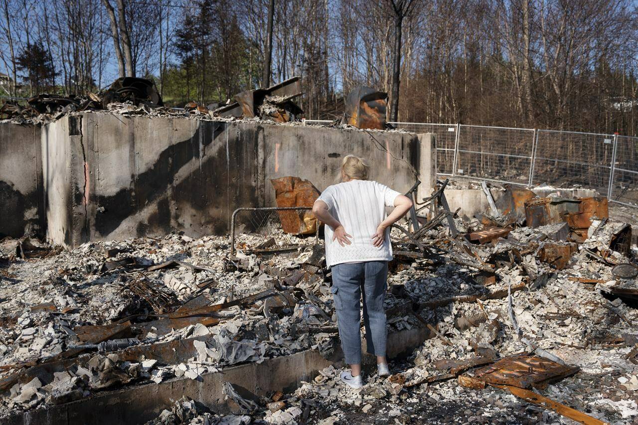 Maureen McGee searches for belongings in the ruins of her family’s home after it was destroyed in a wildfire earlier this month in the suburban community of Hammonds Plains, N.S., outside of Halifax on Thursday, June 22, 2023. Seven months after a wildfire left a dark, 1,000-hectare scare on the western suburbs of Halifax, less visible damage persists in the lives of those who lost their homes. THE CANADIAN PRESS/Darren Calabrese