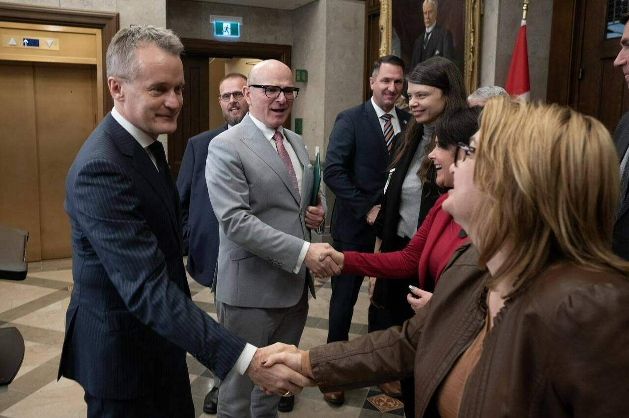 Members of the LGBTQ+ community have long faced discrimination and prejudice in Canada and beyond, having to fight for job protection, access to services and basic human rights. Employment, Workforce Development and Official Languages Minister Randy Boissonnault and Labour and Seniors Minister Seamus O’Regan shake hands with labour leaders after making an announcement in the Foyer of the House of Commons, in Ottawa, Tuesday, Dec. 5, 2023. THE CANADIAN PRESS/Adrian Wyld