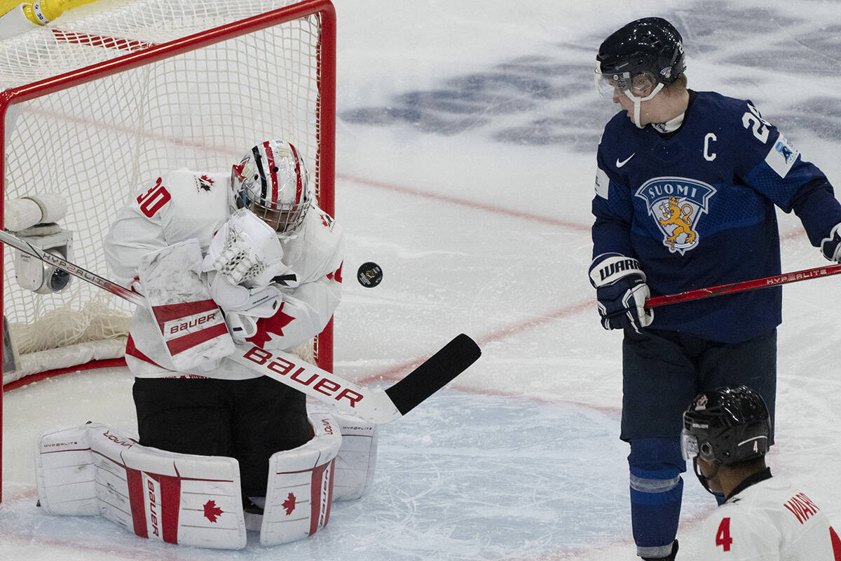 Canada’s goaltender Mathis Rousseau (30) makes a save against Finland’s Jere Lassila (28) during third period hockey action at the IIHF World Junior Hockey Championship in Gothenburg, Sweden on Tuesday, Dec 26, 2023. THE CANADIAN PRESS/Christinne Muschi