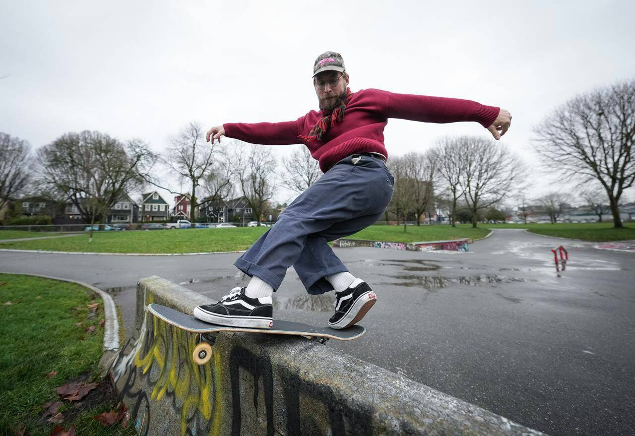 Cole Nowicki performs a frontside rock and roll while posing for a photograph at the Strathcona skatepark in Vancouver, on Wednesday, December 20, 2023. THE CANADIAN PRESS/Darryl Dyck