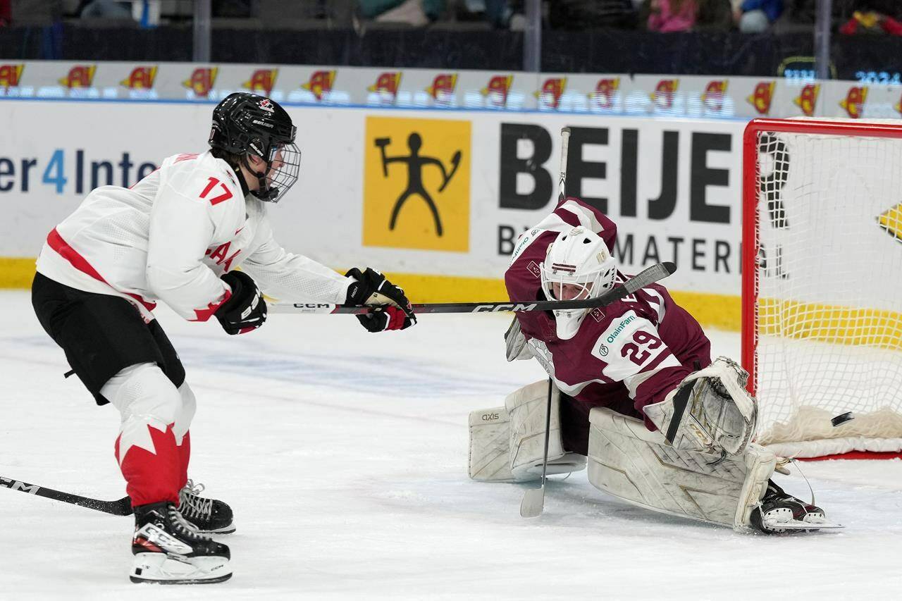 Canada’s Macklin Celebrini (17) scores on Latvia goaltender Linards Feldbergs (29) during second period preliminary round hockey action at the IIHF World Junior Hockey Championship in Gothenburg, Sweden, Wednesday, Dec. 27, 2023. THE CANADIAN PRESS/Christinne Muschi