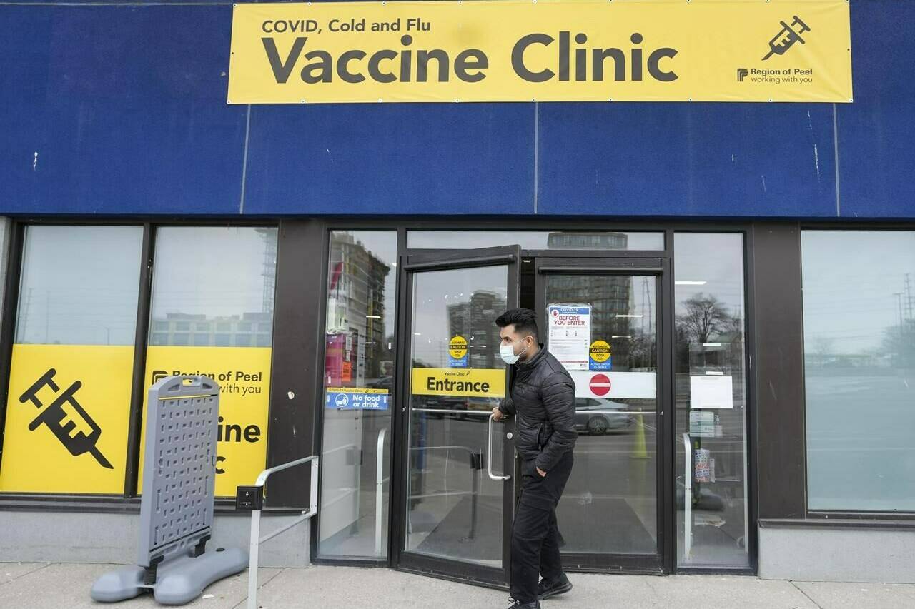 A staff member at a vaccine clinic looks outside the clinic for people waiting to get their shot, in Mississauga, Ont., on Wednesday, April 13, 2022. The B.C. Centre for Disease Control says two children have died from complications related to influenza. THE CANADIAN PRESS/Nathan Denette