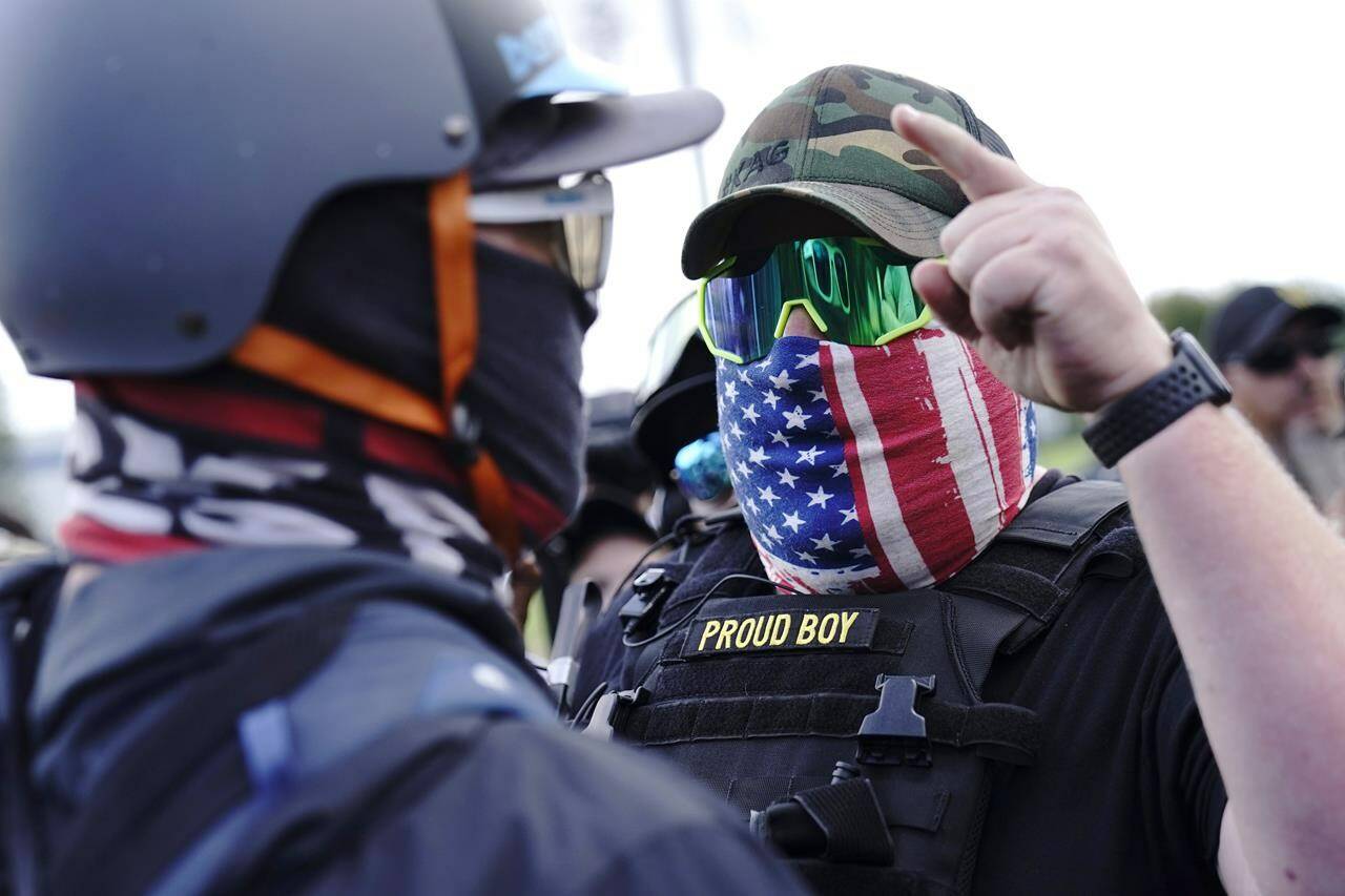 FILE - A right-wing demonstrator gestures toward a counter protester as members of the Proud Boys and other right-wing demonstrators rally in Portland, Ore., Sept. 26, 2020. (AP Photo/John Locher, File)