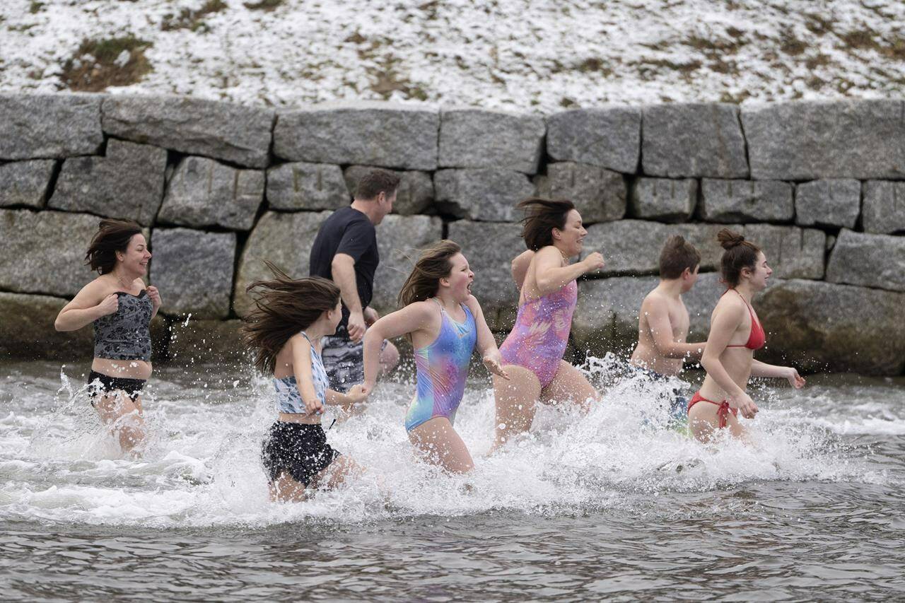 People run into the frigid water in the Northwest Arm off the Atlantic Ocean in Halifax on New Year’s Day, Monday, January 1, 2024. THE CANADIAN PRESS/Darren Calabrese