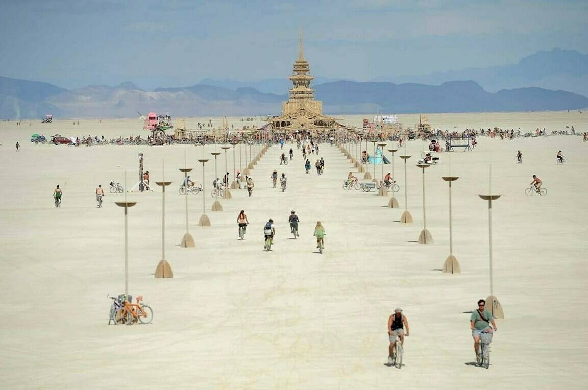 FILE - People walk toward the temple at Burning Man near Gerlach, Nev., on the Black Rock Desert, Friday, Aug. 31, 2012. Burning Man organizers don’t foresee major changes in 2024 thanks to a hard-won passing grade for cleaning up this year’s festival. Some question whether it has veered too far from its core principles of radical inclusion and participation. (Andy Barron/The Reno Gazette-Journal via AP, File)