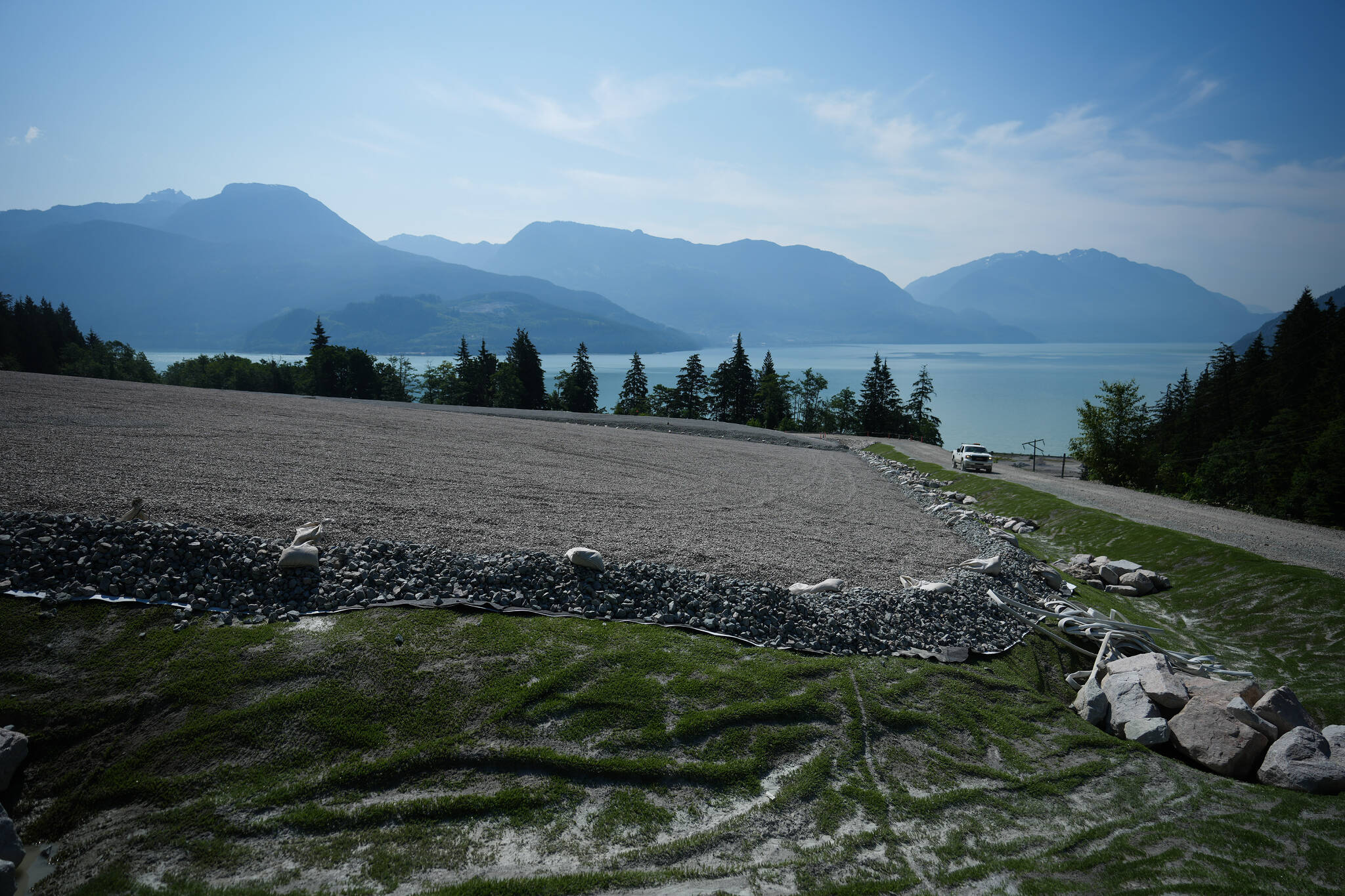 A worker drives past a former landfill undergoing remediation at the Woodfibre LNG export terminal site on Howe Sound, as work continues to prepare for construction, in Squamish, B.C., Wednesday, July 5, 2023. Construction is expected to begin later this year on the liquefied natural gas export facility which is being built on the site that was used as a pulp and paper operation for nearly 100 years before closing in 2006. THE CANADIAN PRESS/Darryl Dyck