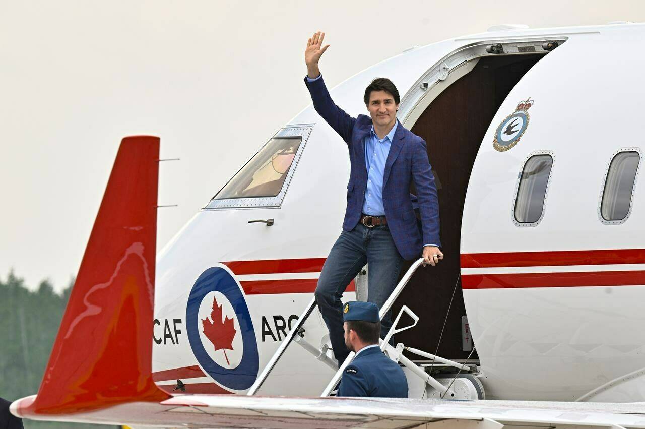 Prime Minister Justin Trudeau waves as he steps off a plane, Wednesday, June 14, 2023 at CFB Bagotville in Saguenay, Que. The plane that flew Trudeau to Jamaica for a family vacation broke down earlier this week, prompting the Canadian military to send a second aircraft with a repair crew to the Caribbean island. THE CANADIAN PRESS/Jacques Boissinot