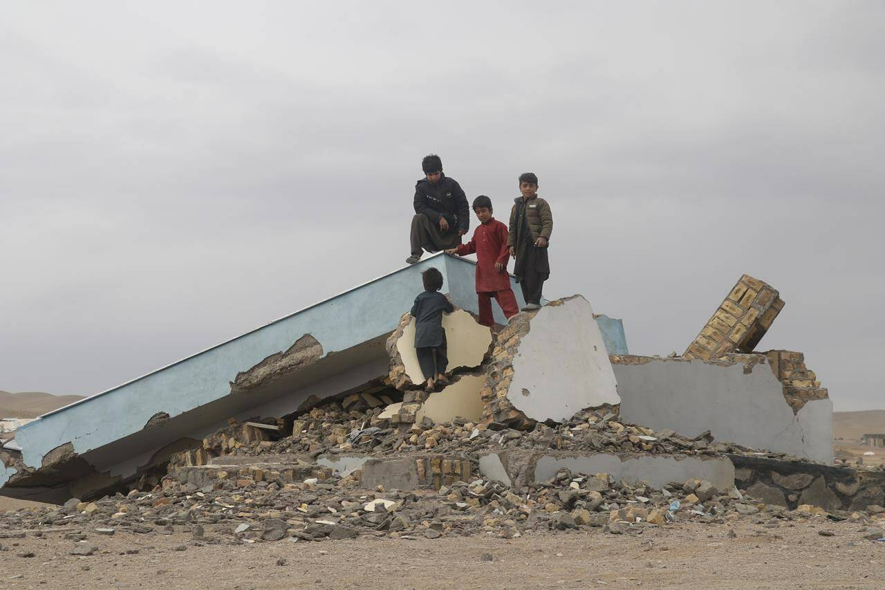 Afghan children climb on a destoryed building in Zindan Jan, Afghanistan, on Thursday, Jan. 4, 2024, three months after a massive earthquake hit the area. (AP Photo/ Omid Haqjo)