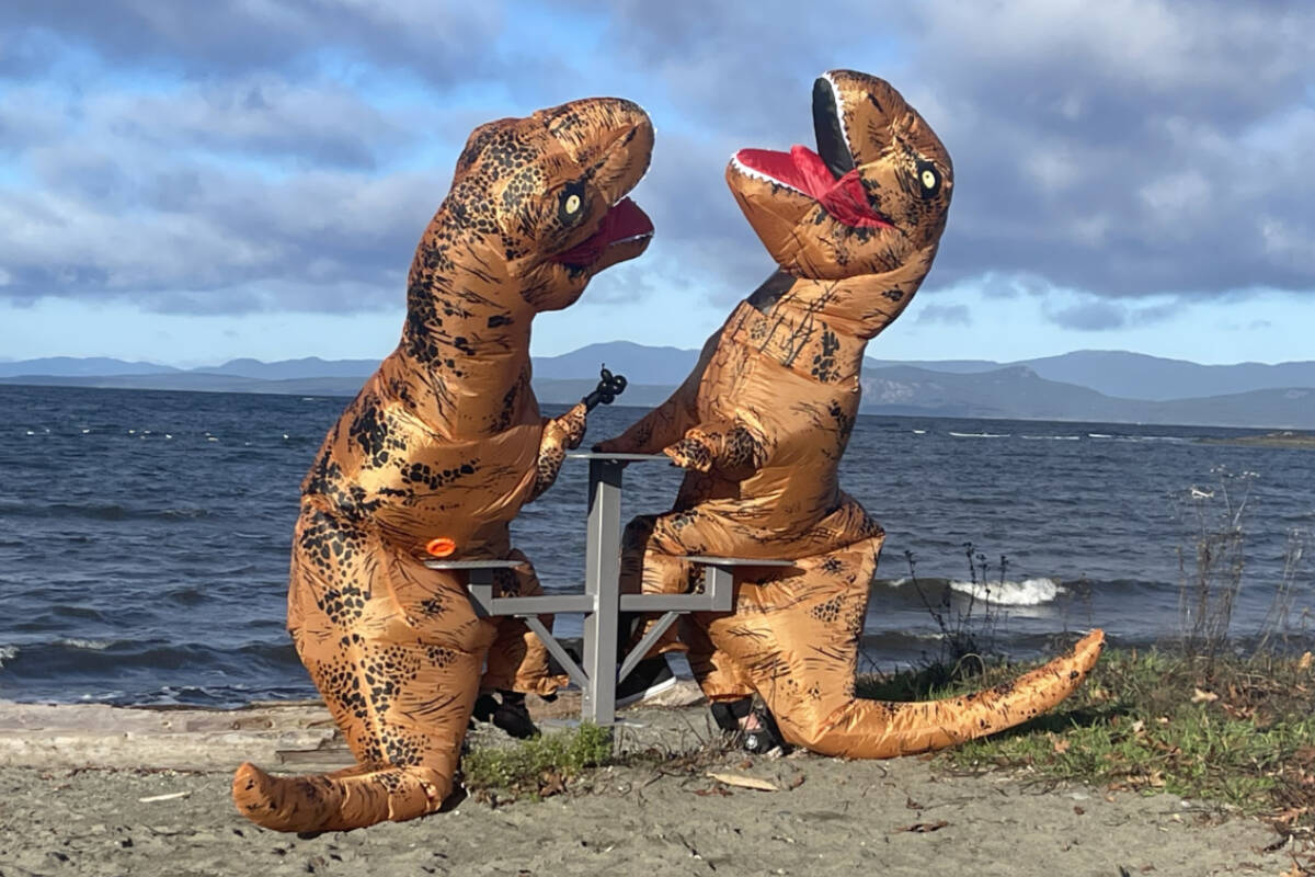 Vienna Matthews and Jordan King in their T. rex costumes drew a lot of attention at the Parksville Community Park on Saturday, Jan. 6. (Michael Briones photo)