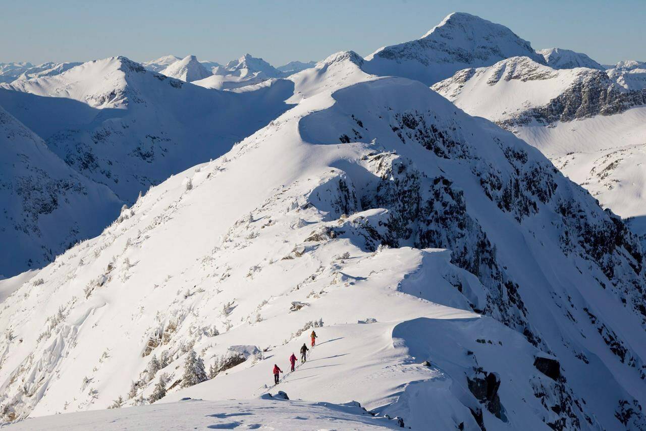 Backcountry skiers are dwarfed by the mountains as they make their way along a mountain ridge near McGillivray Pass Lodge located in the southern Chilcotin Mountains of British Columbia, Tuesday, Jan. 10, 2012. Environment Canada is warning parts of northern British Columbia to expect wind chill values as cold as -50 C for at least the rest of the week. THE CANADIAN PRESS/Jonathan Hayward