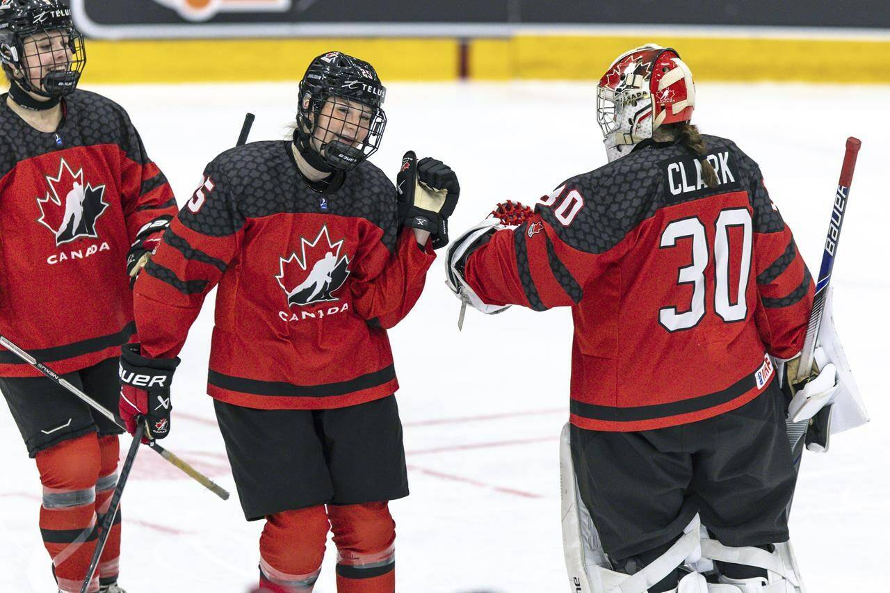Canada’s Gracie Graham, centre, reacts with goalkeeper Hannah Clark, right, during the Women’s U18 Ice Hockey World Championship match between Canada and Sweden, in Ostersund, Sweden, Sunday, Jan. 15, 2023. Graham had a goal and two assists as Canada advanced to the semifinals of the world women’s under-18 hockey championship with a 6-0 win over host Switzerland on Thursday. THE CANADIAN PRESS/Per Danielsson-TT News Agency via AP