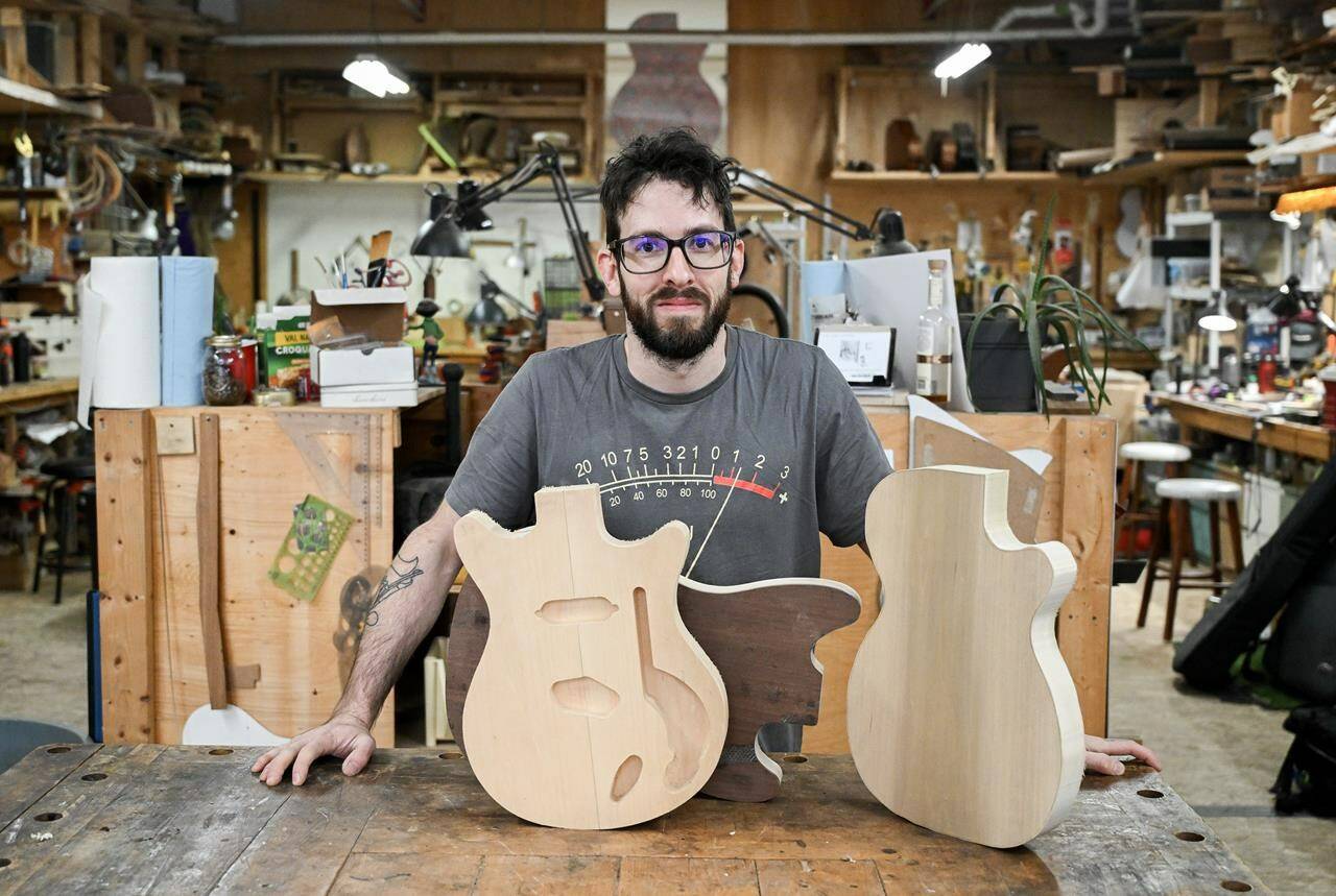 Guitar maker Nicolas Delisle poses at the Mile End Guitar Co-op in Montreal, Sunday, January 7, 2024. Delisle, a luthier by trade makes all his guitars by hand and for some uses century-old recycled wood. THE CANADIAN PRESS/Graham Hughes