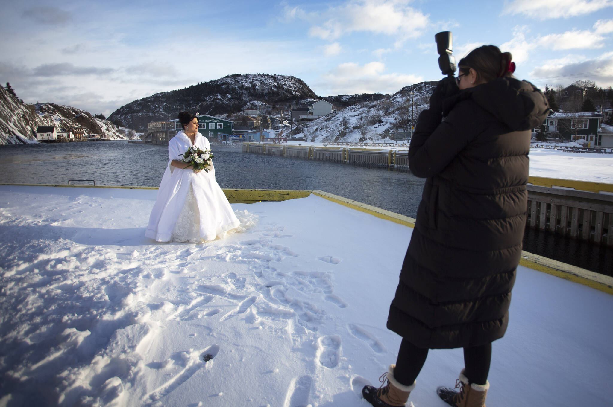 Newlywed Alicia Greene poses for her wedding pictures in historic Quidi Vidi in St. John’s on Saturday, January 6, 2024 following the first significant snow fall of the winter. Quidi Vidi is a neighbourhood in St. John’s, Newfoundland and Labrador. THE CANADIAN PRESS/Paul Daly