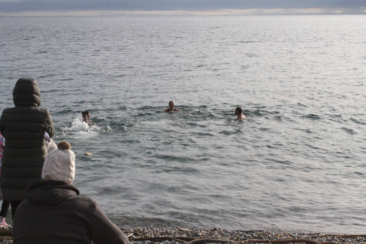 A group of swimmers take the plunge into the cold waters of the Salish Sea. (News Staff/Thomas Eley)