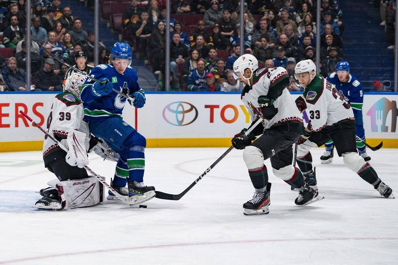 Arizona Coyotes goaltender Connor Ingram (39) stops a shot as Matt Dumba (24) and Travis Dermott (33) defend while Vancouver Canucks’ Brock Boeser (6) watches during the first period of an NHL hockey game in Vancouver on Thursday, Jan. 18, 2024. THE CANADIAN PRESS/Ethan Cairns