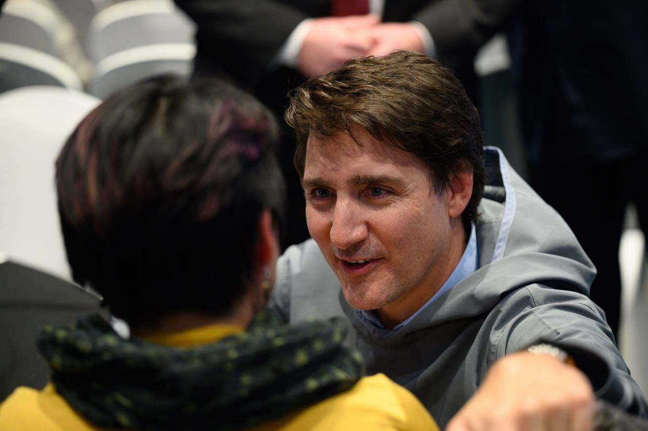 Prime Minister Justin Trudeau speaks with a member of the public at an event follwing the signing of the Nunavut devolution agreement in Iqaluit on Thursday, January 18, 2024. THE CANADIAN PRESS/Dustin Patar