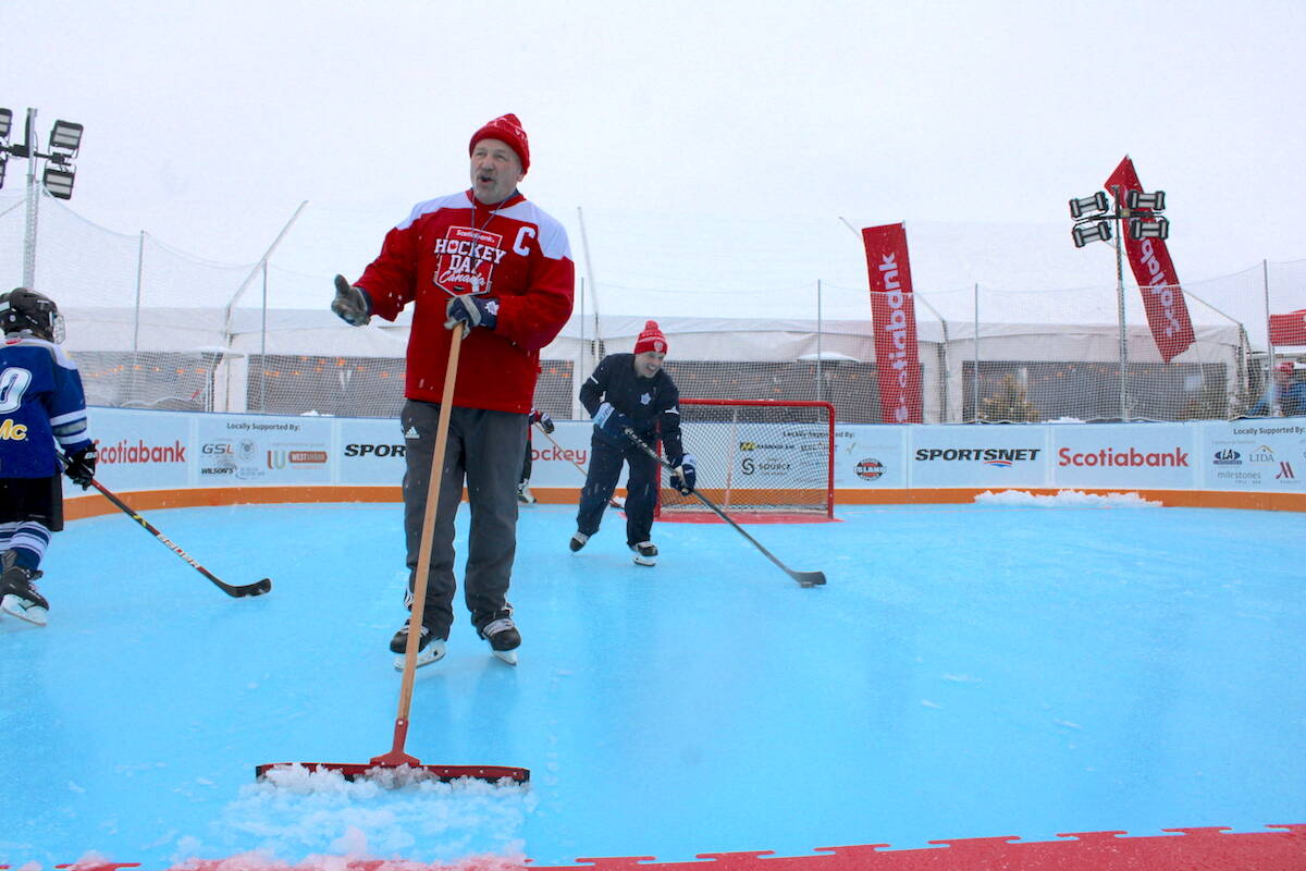 Former NHL player Wendel Clark clears snow from the synthetic ice rink set up at Ship Point as Victoria hosts Hockey Day in Canada. (Jake Romphf/News Staff)