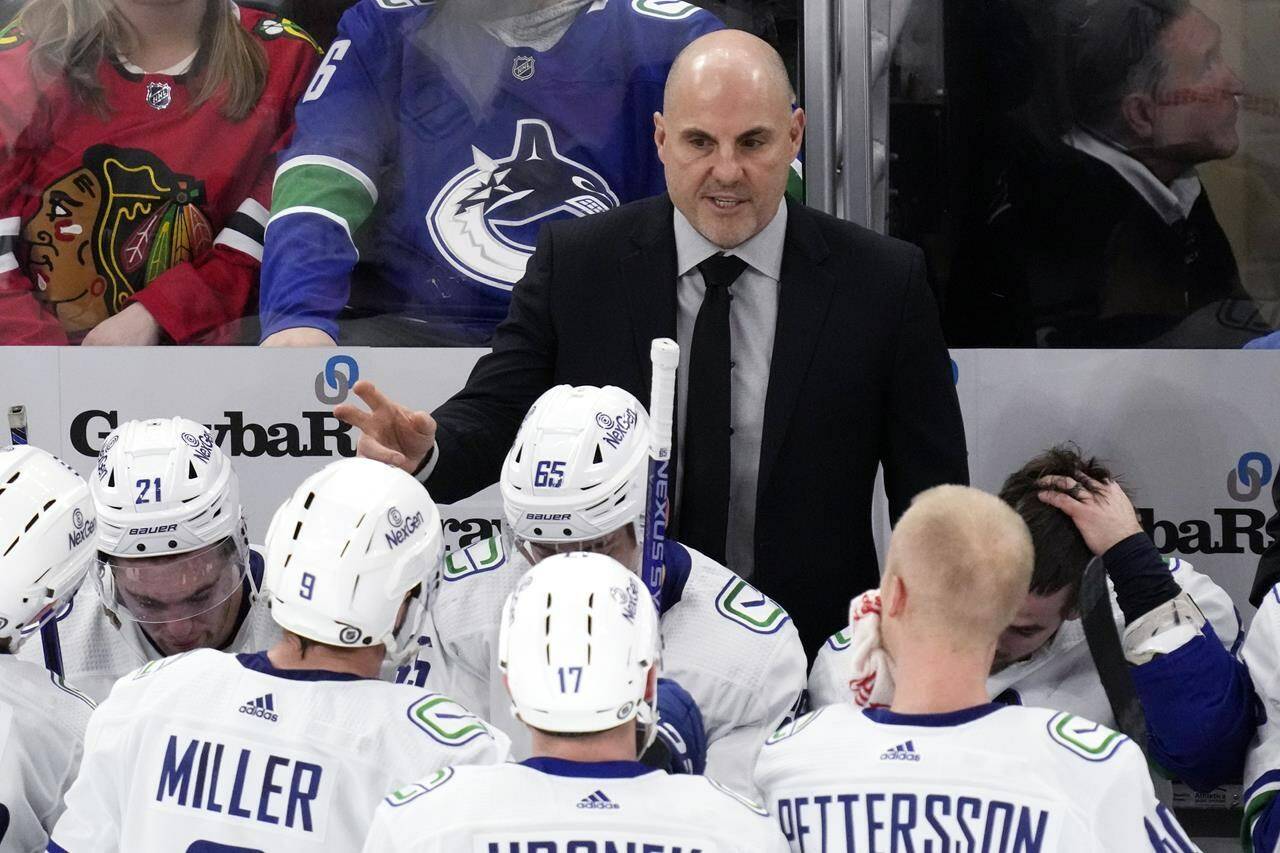 Vancouver Canucks head coach Rick Tocchet, top, talks to players during the third period of an NHL hockey game against the Chicago Blackhawks in Chicago, Sunday, Dec. 17, 2023. Rick Tocchet took over the Vancouver Canucks a year ago, with the team struggling to find consistency in how it played, combined with wins. THE CANADIAN PRESS/AP, Nam Y. Huh