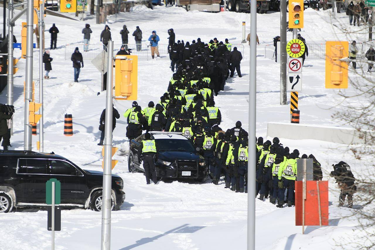 A judge’s declaration that the federal government was unjustified in using Canada’s emergency legislation to quell a weeks-long protest in Ottawa has left the administrator of a downtown church feeling the court disregarded infringements of her rights. A lineup of police officers assemble on Colonel By Drive near the truck blockade in Ottawa, on Friday, Feb. 18, 2022. THE CANADIAN PRESS/Justin Tang