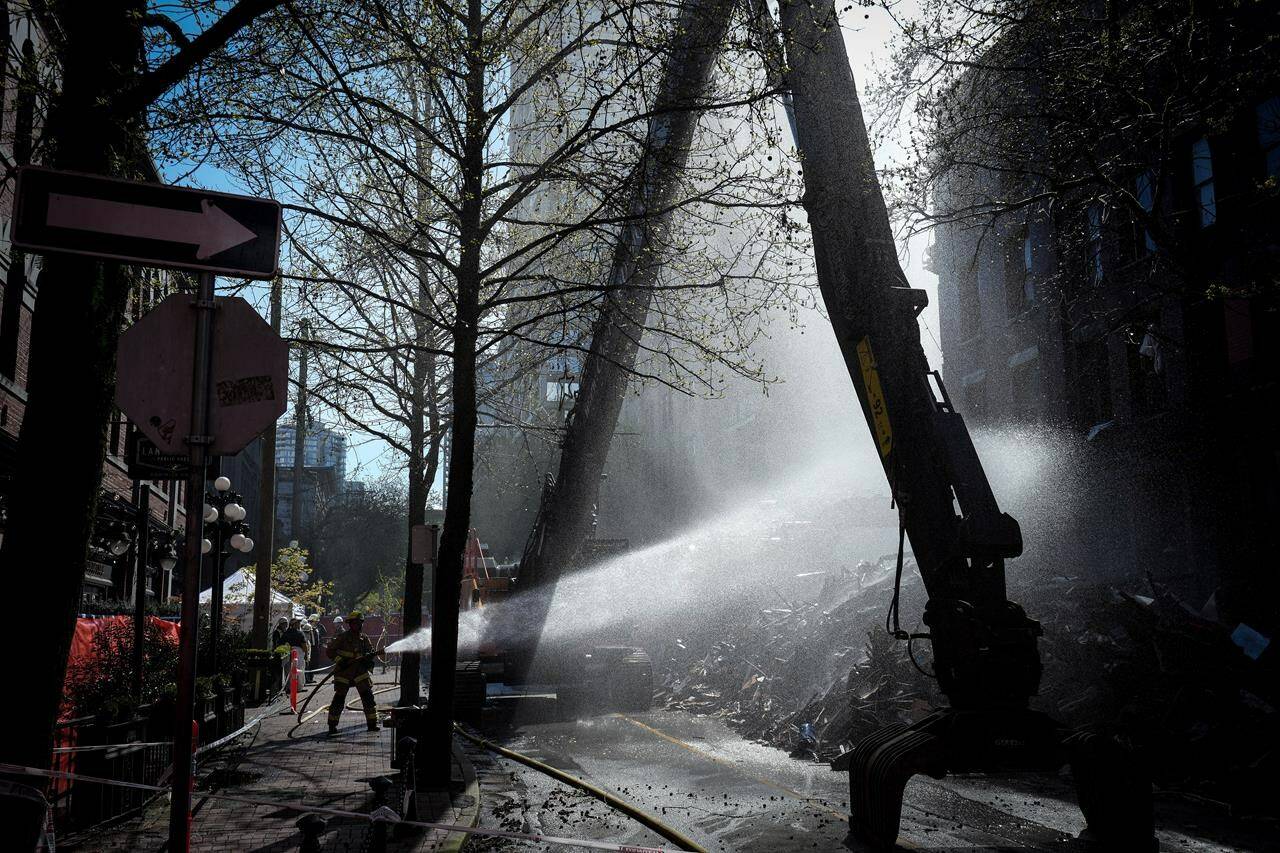 A coroner’s inquest into the deadly Winters Hotel fire in Vancouver has seen video footage of the blaze from inside the rooming facility, showing heavy smoke billowing from a unit, then flames a few minutes later. A firefighter sprays water on debris during demolition of the Winters Hotel in Vancouver, B.C., Friday, April 22, 2022. THE CANADIAN PRESS/Darryl Dyck