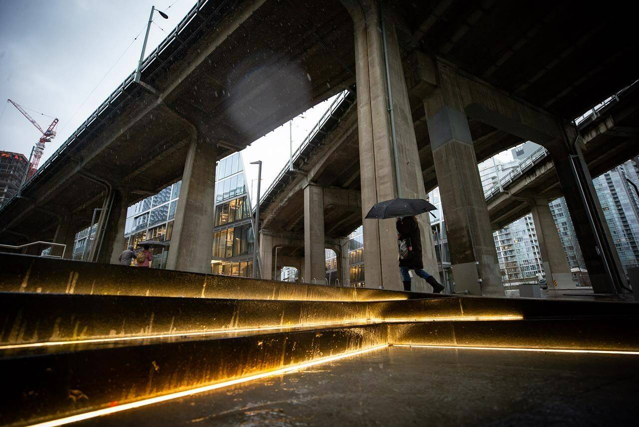 A person carries an umbrella as heavy rain falls in Vancouver, B.C., Tuesday, Jan. 5, 2021. Balmy weather and a series of rainstorms forecast for British Columbia’s South Coast have set off flood advisories for rivers, streams and low-lying areas.THE CANADIAN PRESS/Darryl Dyck