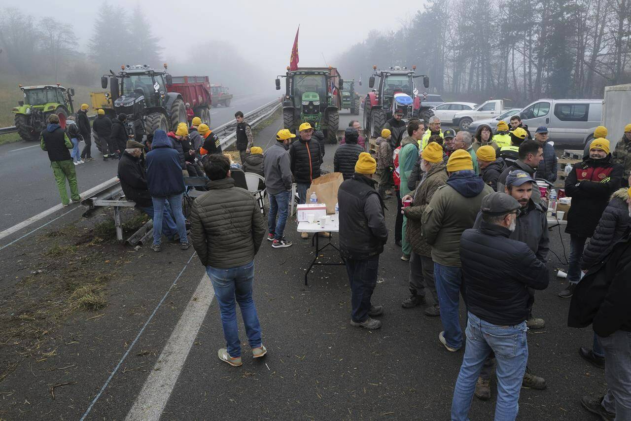 Farmers block a highway, near Agen, southwestern France, Saturday, Jan. 27, 2024. French farmers have vowed to continue protesting and are maintaining traffic barricades on some of the country’s major roads. The government announced a series of measures Friday but the farmers say these do not fully address their demands. (AP Photo/Fred Scheiber)