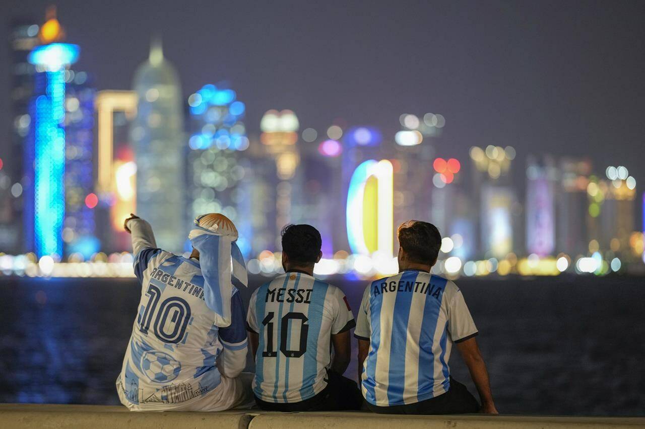 Fans of Argentina sit on Doha corniche, in Doha, Qatar, Monday, Dec. 12, 2022. Toronto and Vancouver are set to get a tourism boost from the World Cup, but one expert warns to be wary of rosy projections. THE CANADIAN PRESS/AP-Andre Penner