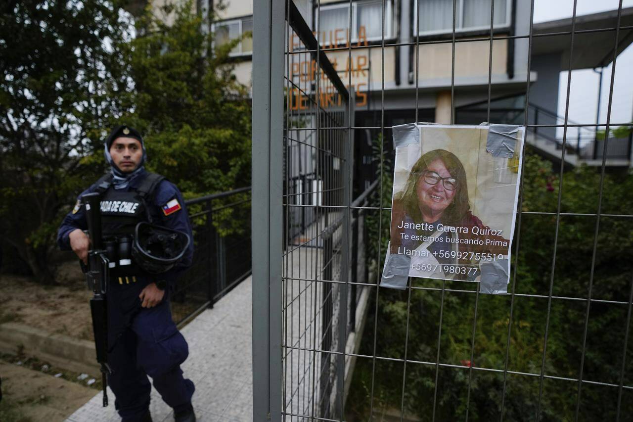 A missing persons sign hangs outside a school after deadly forest fires affected the Villa Independencia neighborhood of Vina del Mar, Chile, Tuesday, Feb. 6, 2024. Hundreds of people remain missing. (AP Photo/Esteban Felix)