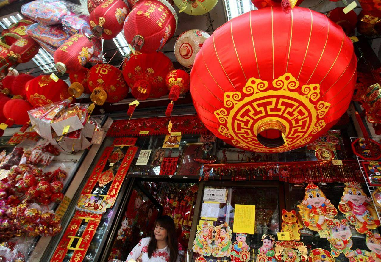FILE - This Feb. 6, 2013 file photo shows a woman walking out a shop selling seasonal items ahead of Chinese New Year in Chinatown in Bangkok, Thailand. In many Asian cultures, the Lunar New Year is a celebration marking the arrival of spring and the start of a new year on the lunisolar calendar. It's the most important holiday in China where it's observed as the Spring Festival. It's also celebrated in South Korea, Vietnam and diaspora communities around the world. (AP Photo/Sakchai Lalit, File)